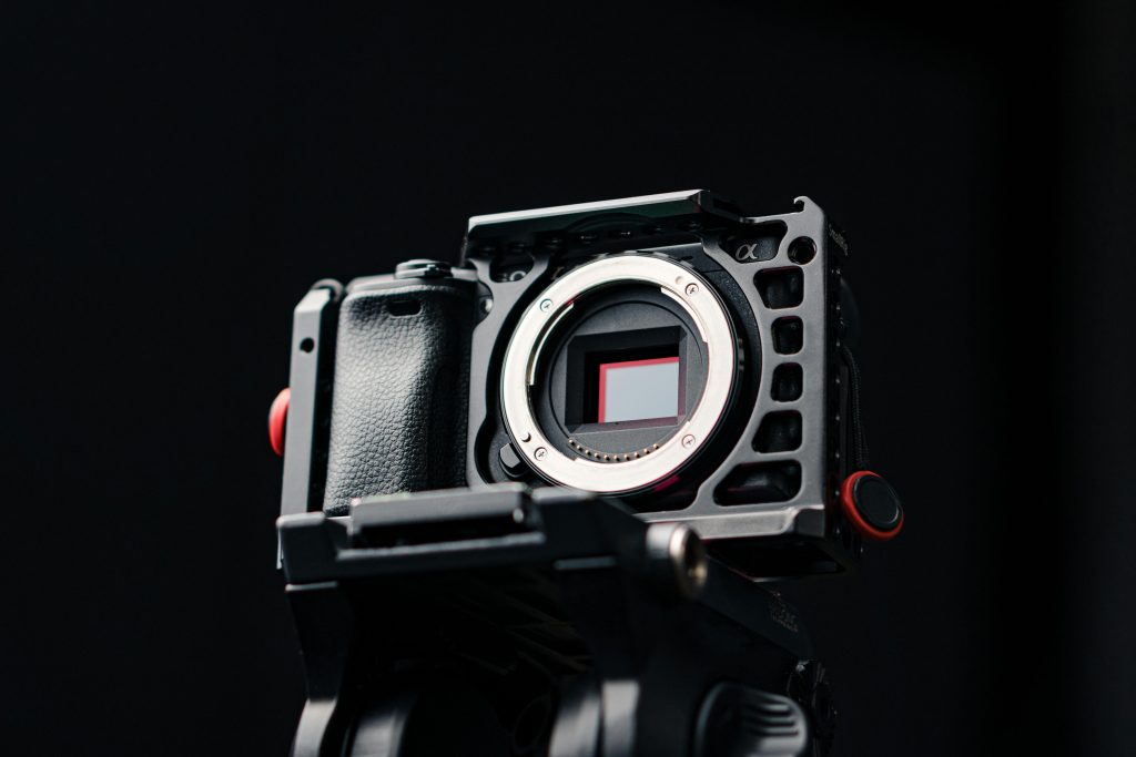 Detailed close-up of a mirrorless camera body with a matte black finish, highlighting its intricate design.
