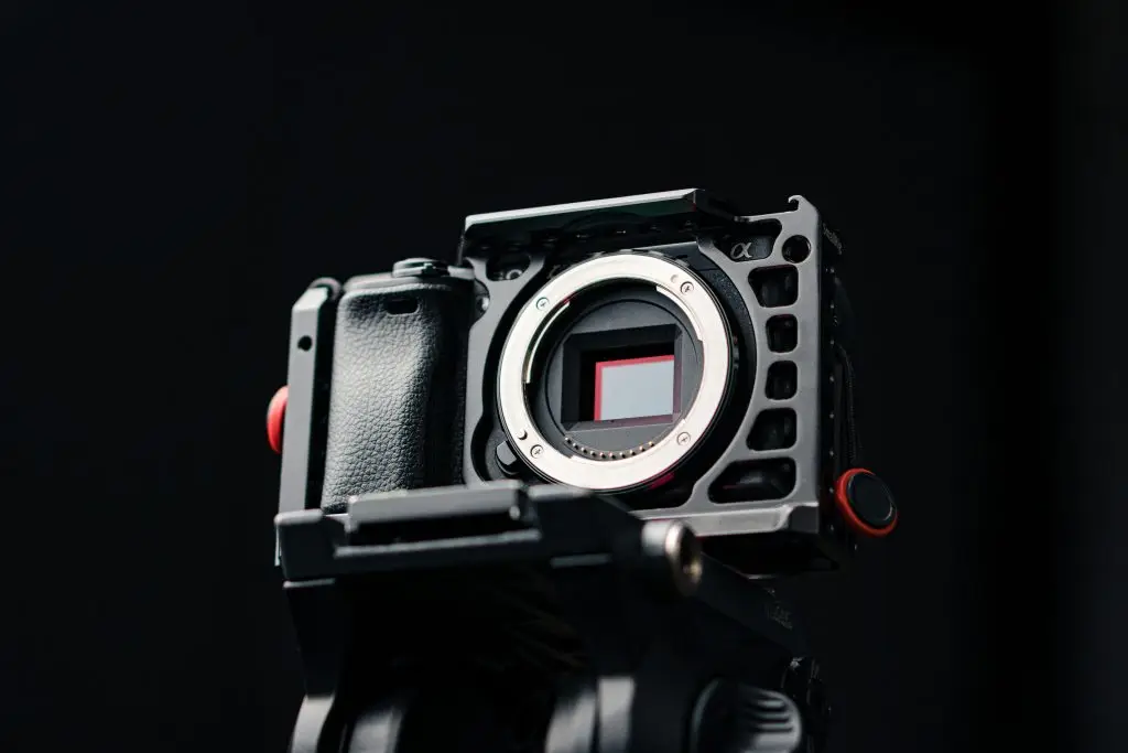Uitrusting Detailed close-up of a mirrorless camera body with a matte black finish, highlighting its intricate design.
