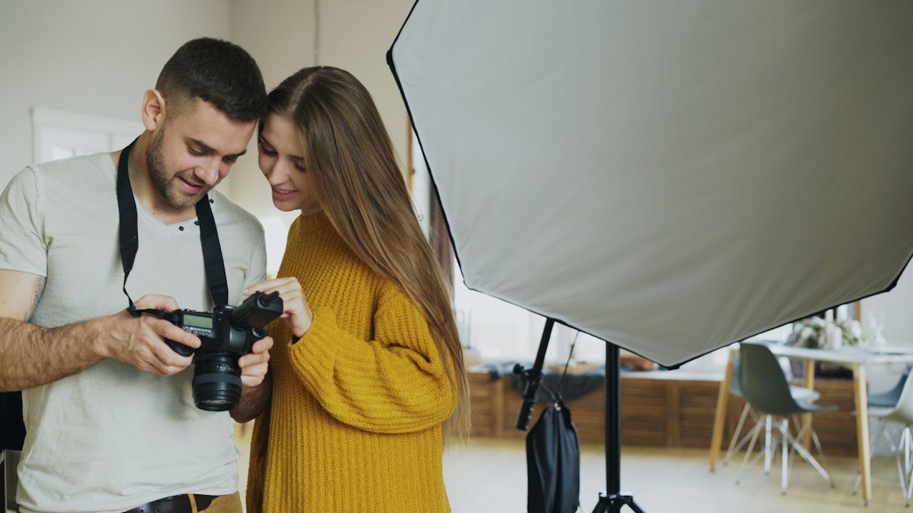 Mastering the First Impression: Your intriguing post title goes here Photographer shares camera screen with model indoors in a photography studio.